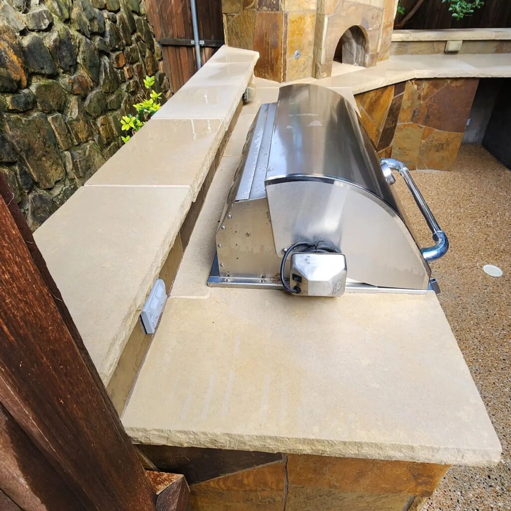 A stone bench with a pizza oven in the middle of it.