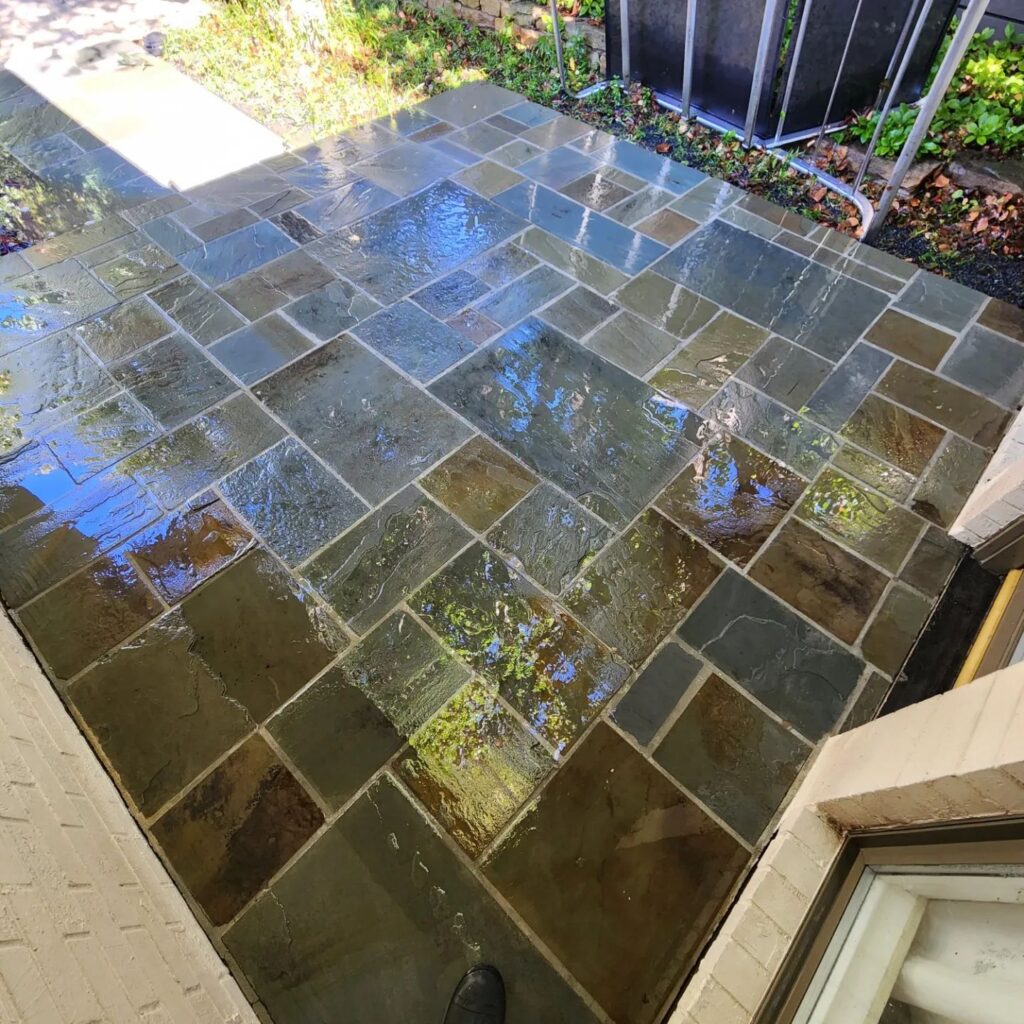 A patio with tile on the ground and water in it.