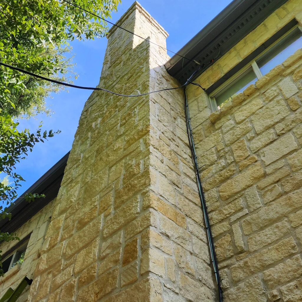 A tall brick building with a large window.