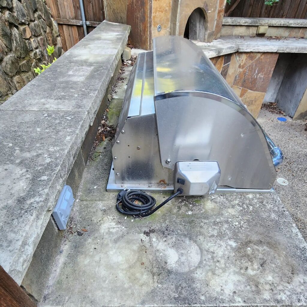 A metal object sitting on top of concrete.